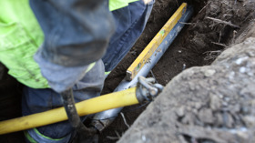 Gult gasrør er ved at blive lagt i en udgravet rende